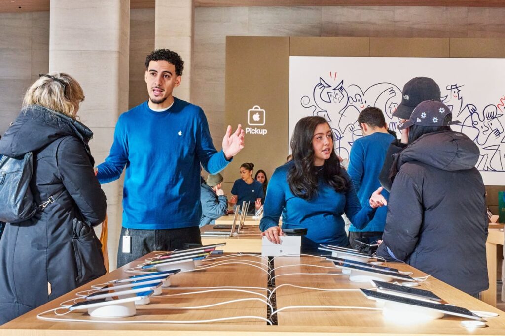 Customers and salespeople inside an Apple store.