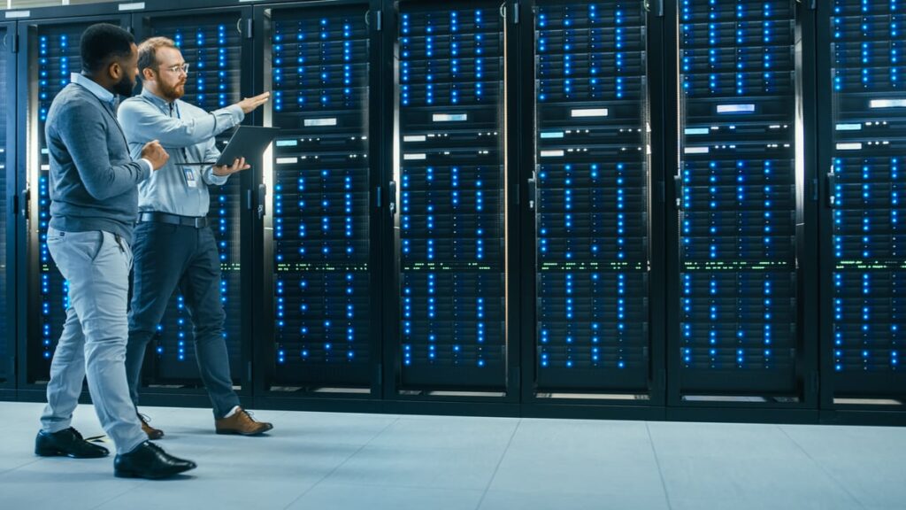 Two people walking through a data center.