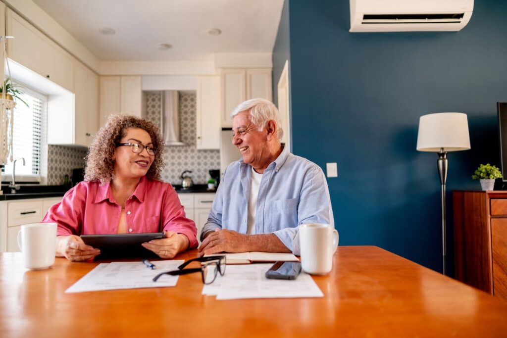 Smiling couple looking at tablet in the kitchen.