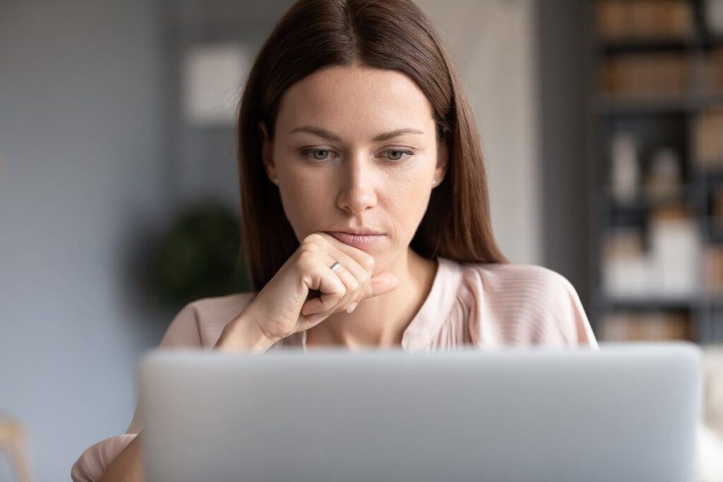 Person looking intently at laptop.