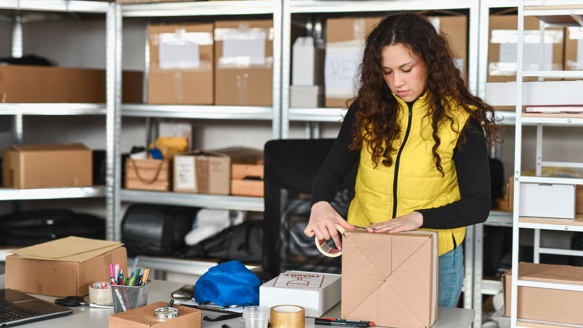 A woman packing up a sold item in her storage unit.