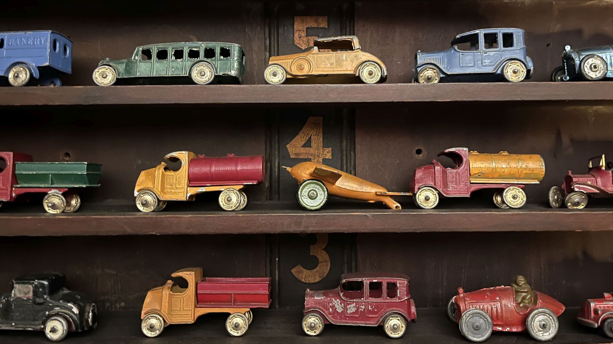 Antique toy cars and trucks. Vintage 1920s toy cars and trucks on shelves.