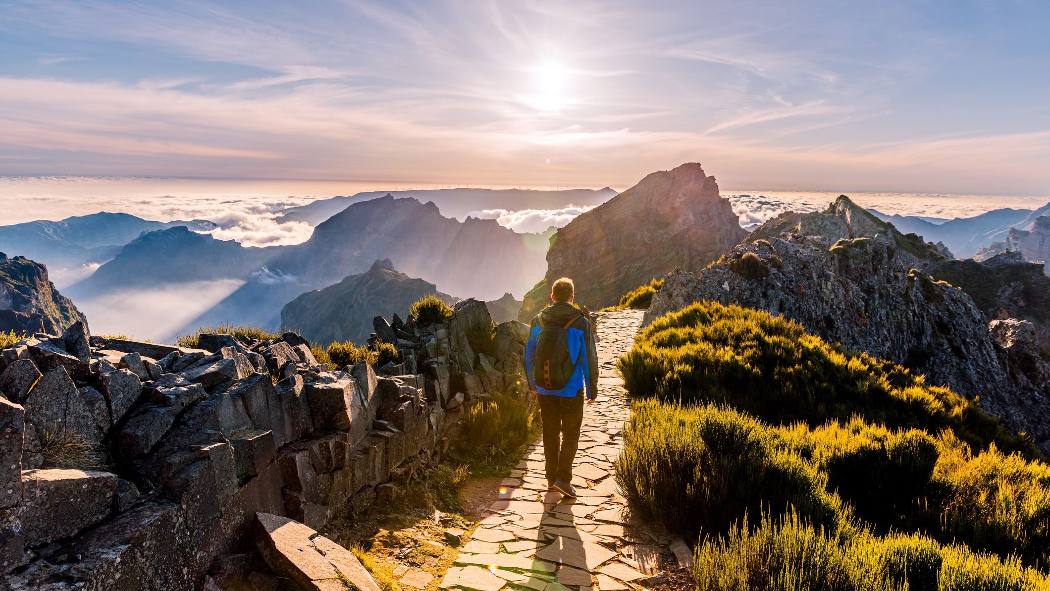 a hiker walking along a mountaintop path