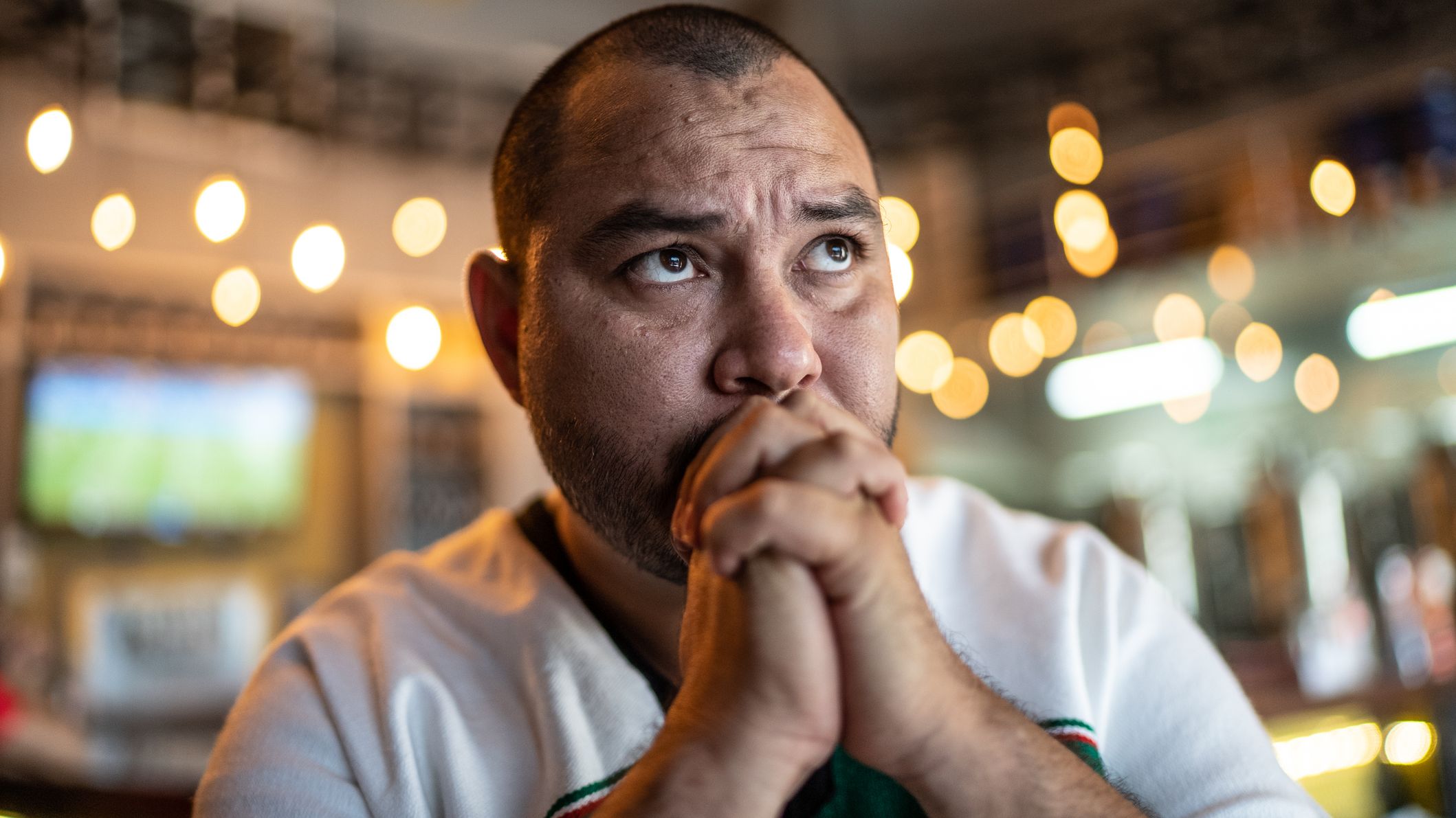 a sad soccer fan watching a match at the pub