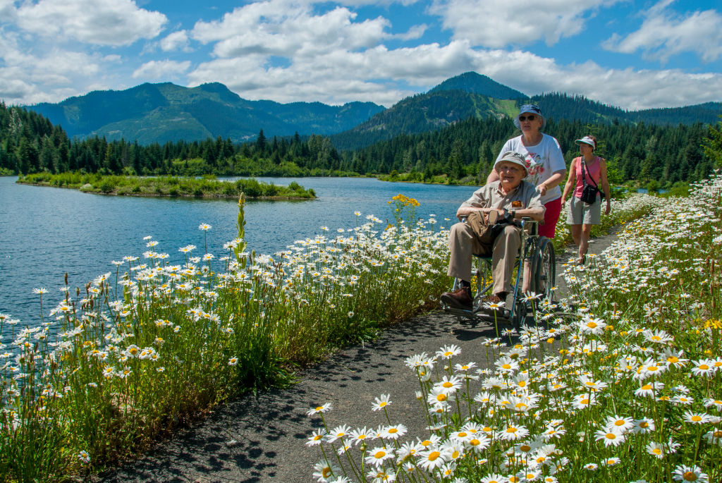 A group with a wheelchair at Gold Creek Pond, Gold Creek Recreation Area, in the Cascade Mountains near Snoqualmie Pass in Washington State, United States.