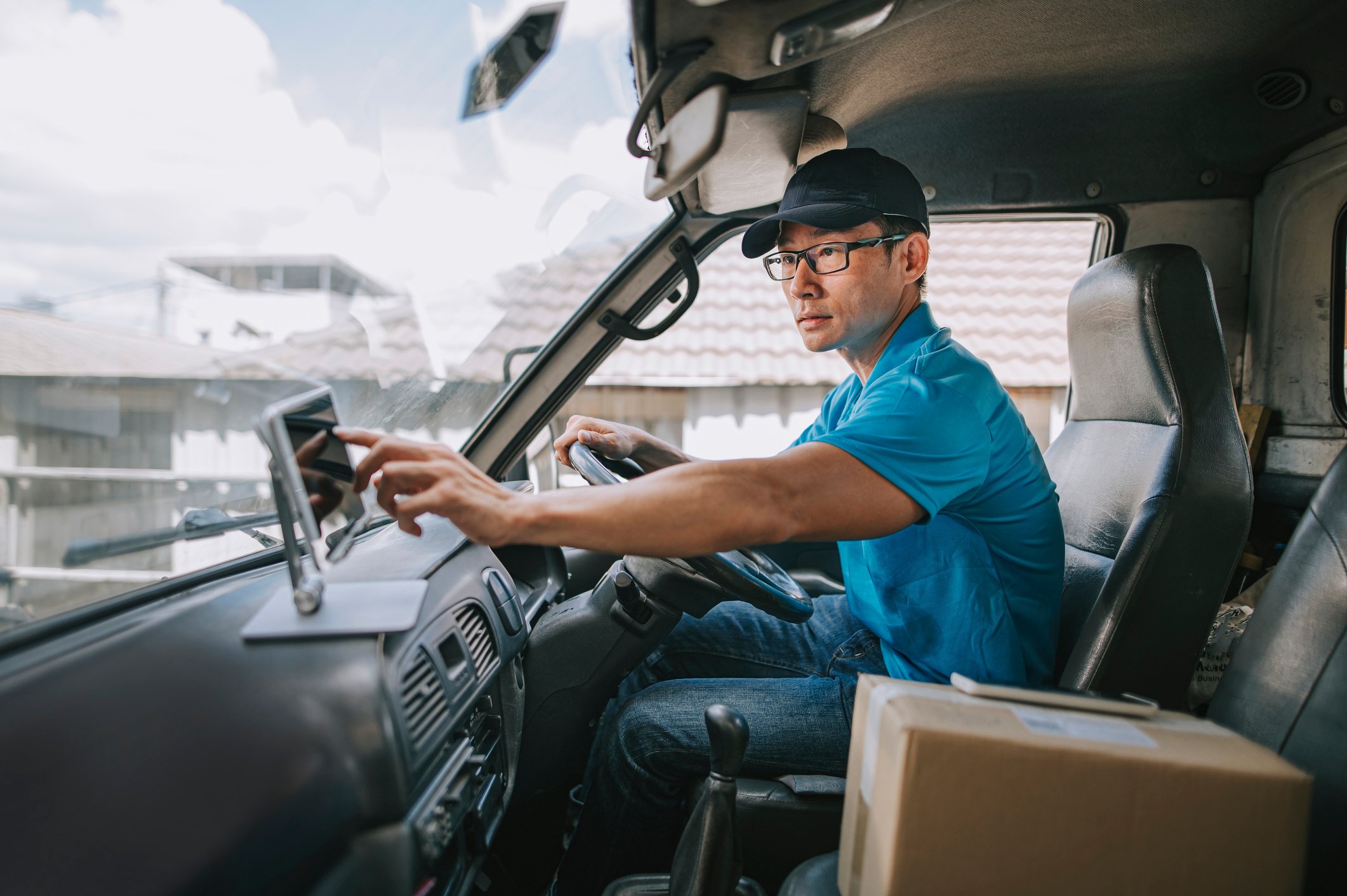 A delivery driver in the front seat of a van.