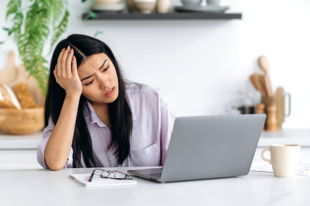 disappointed investor works on laptop.