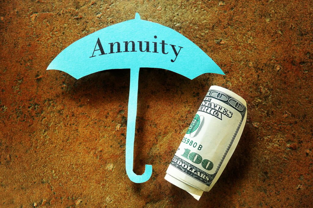 A small blue paper umbrella is protecting a roll of cash.