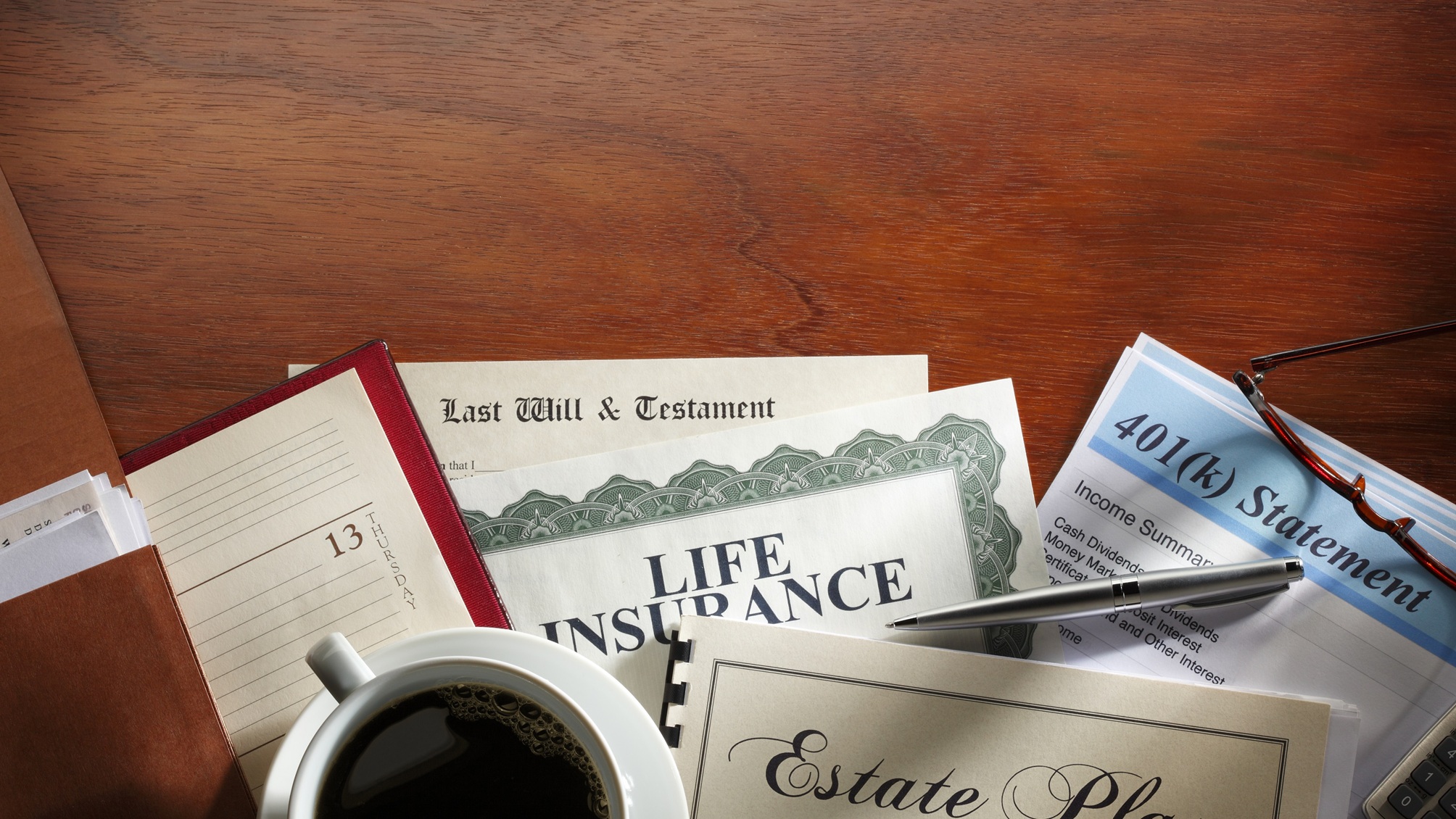 A desk scene with many documents related to estate planning.