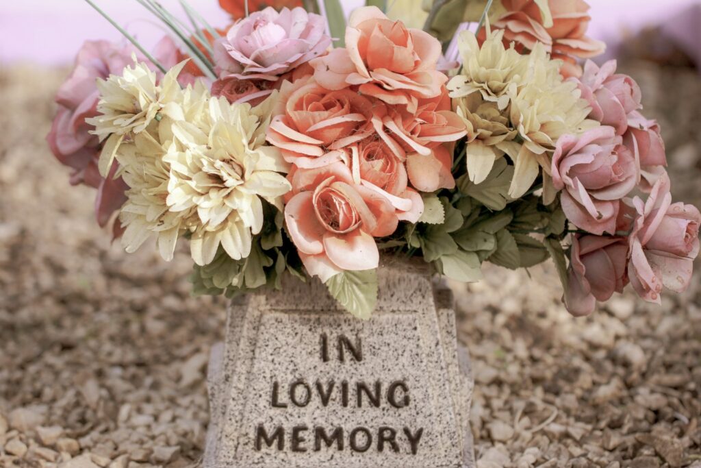 pink and white flowers on gray concrete tomb; cremation vs burial cost
