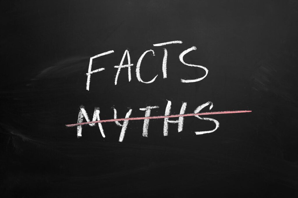 The words facts and myths written in chalk on a blackboard, with the word myths marked through.