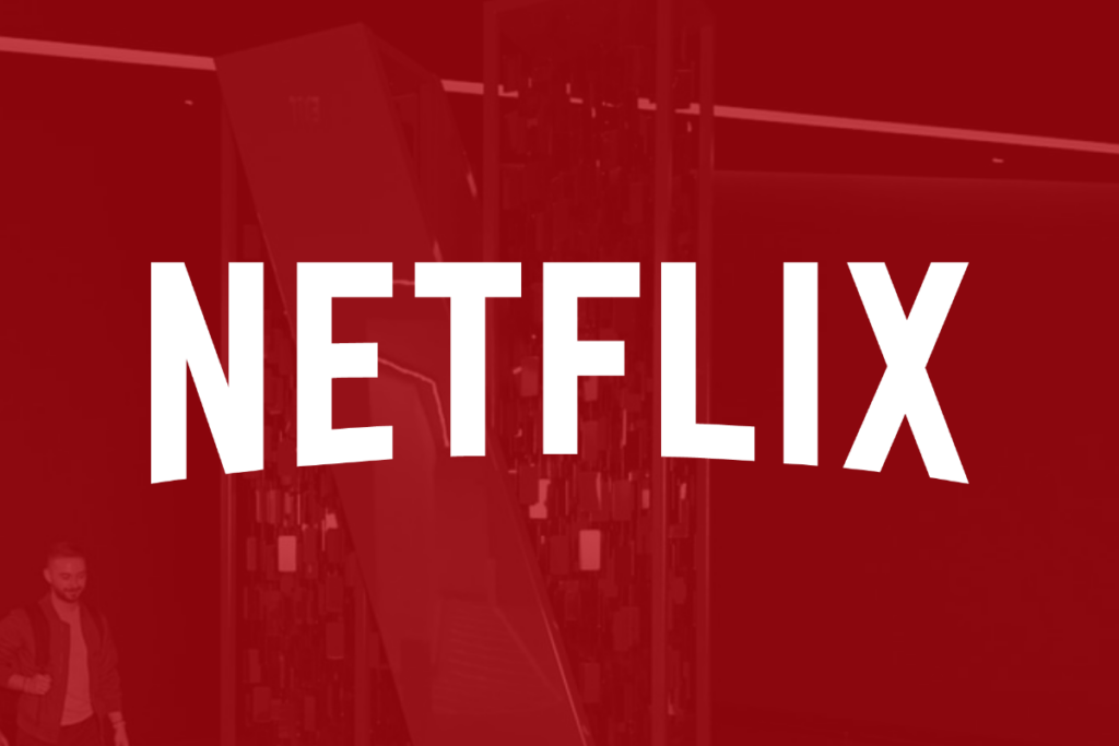 The Netflix logo superimposed over a person walking through the company's lobby.