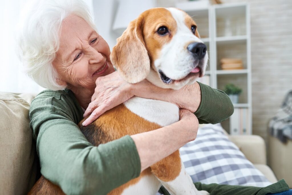 A smiling person holding a dog.