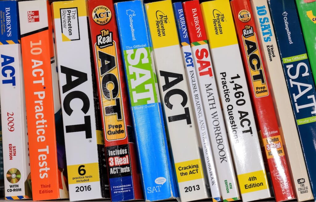 Row of ACT and SAT books contain standardized practice tests for university admissions in USA.