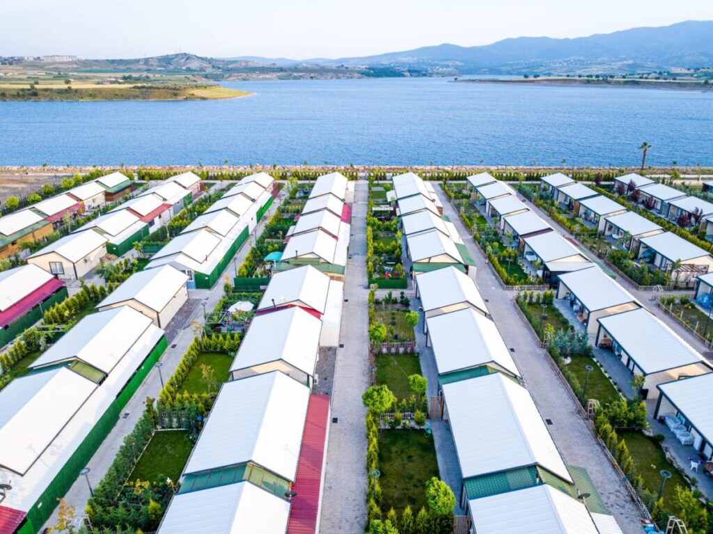 Aerial view of a picturesque village with white-roofed houses near a tranquil lake; cashflow secrets investing