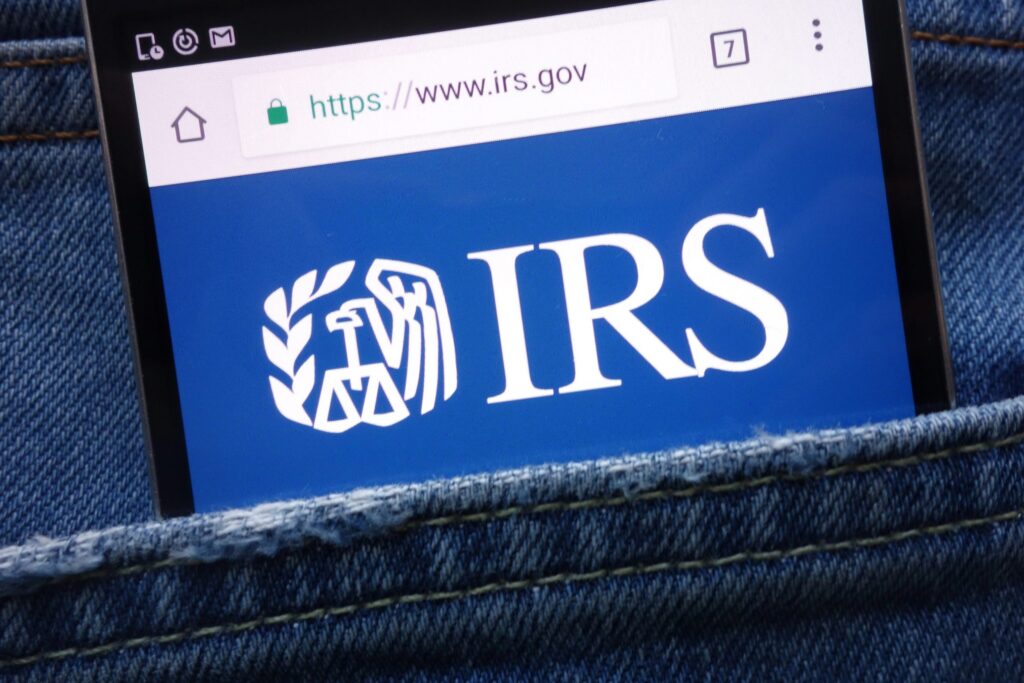 IRS (Internal Revenue Service) website displayed on smartphone hidden in jeans pocket