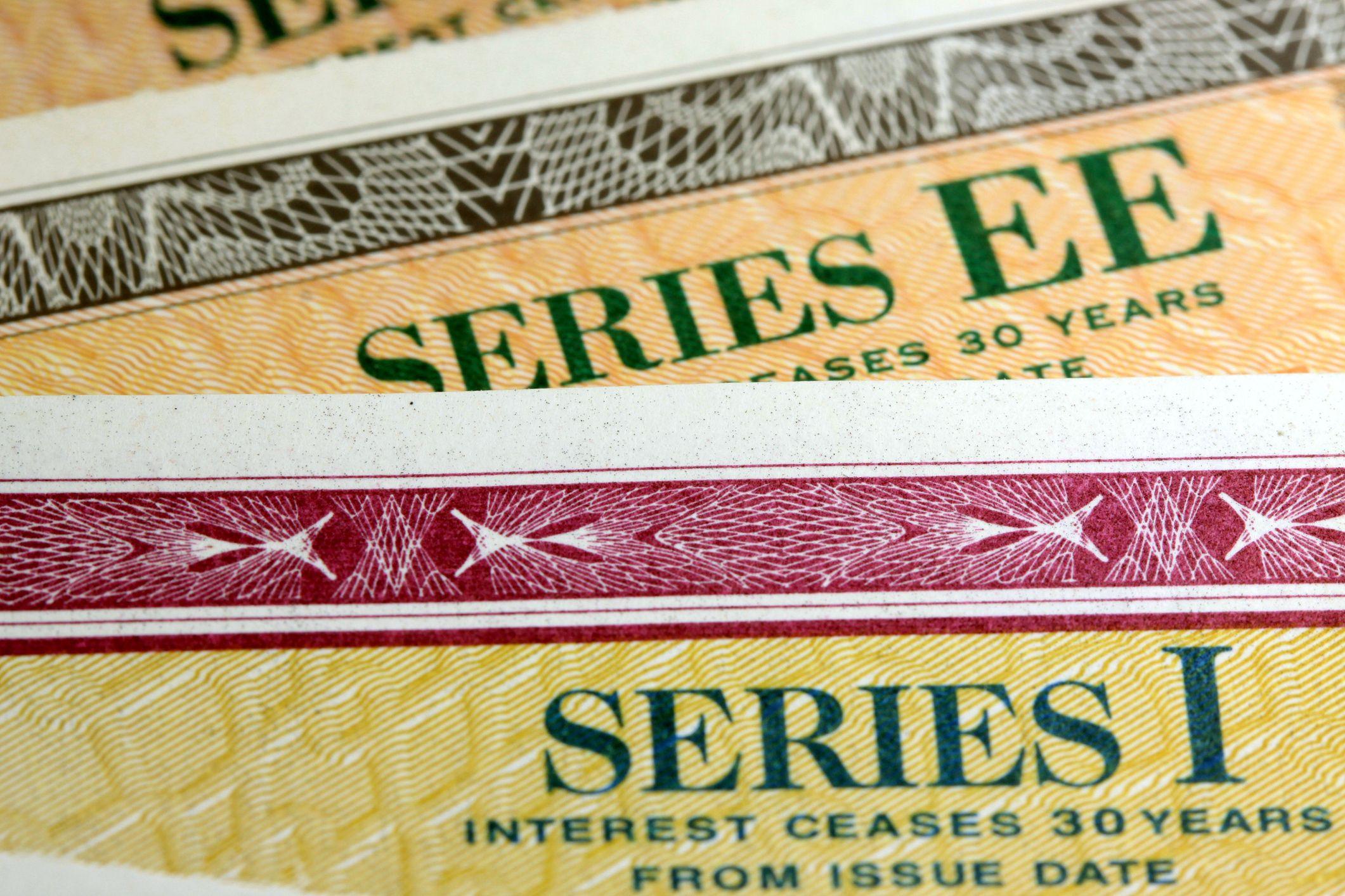 Close-up of overlapping U.S. savings bonds labeled Series EE and Series I with colorful security patterns