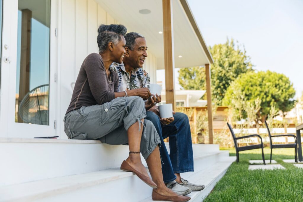 An old couple sitting on a porch in retirement.