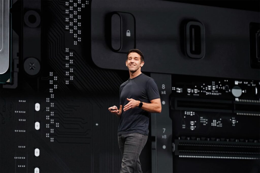 Apple CEO John Ternus walks across a black stage.