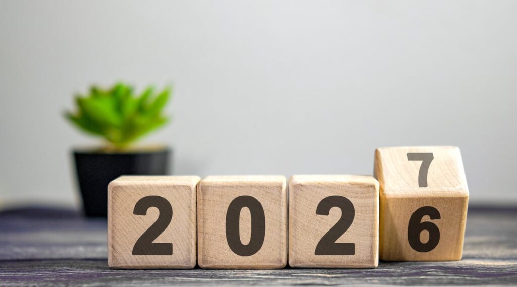 Wood blocks spelling out "2026" with the number six rolling over to show the number seven.