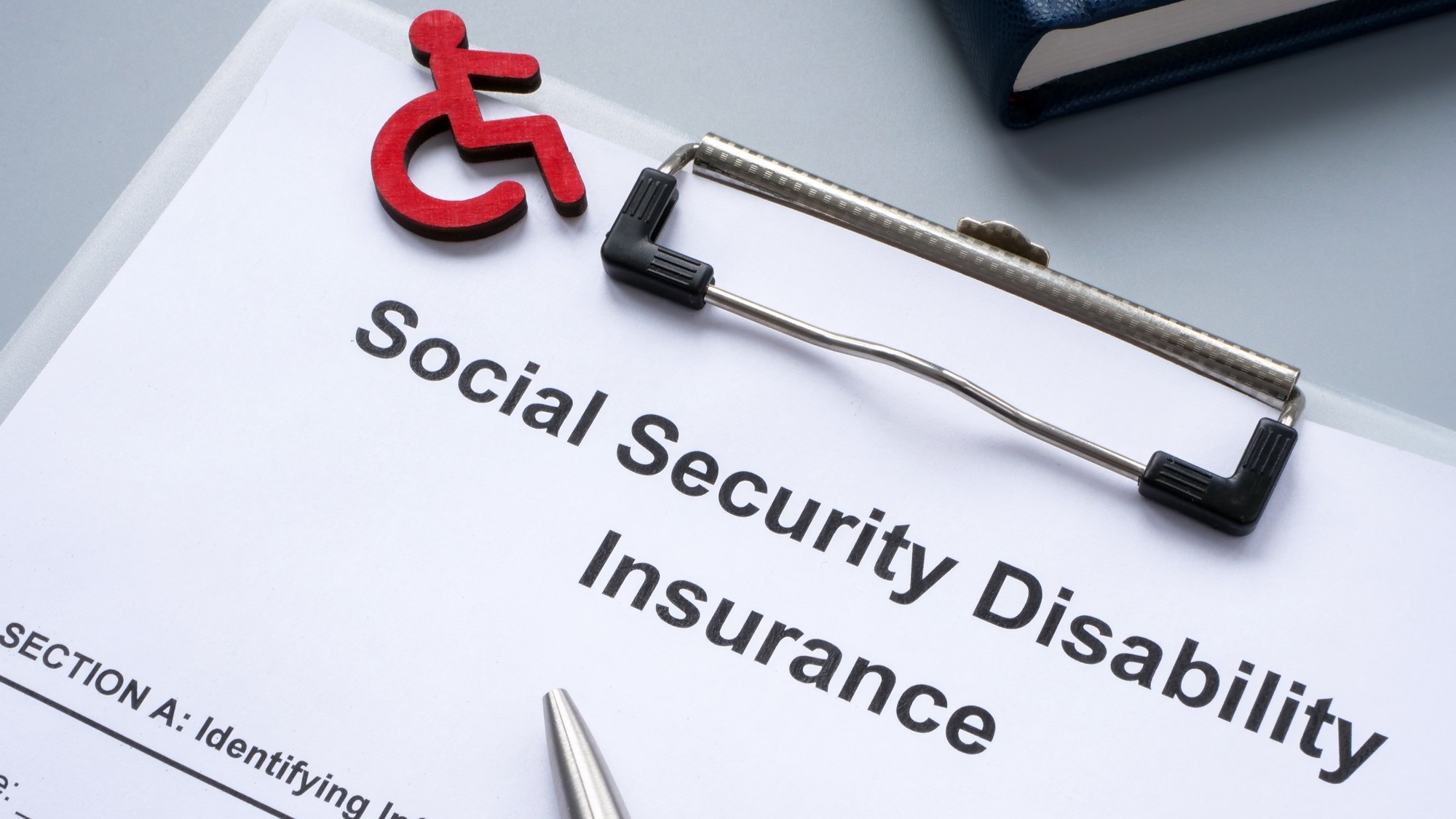 Clipboard with Social Security Disability Insurance SSDI policy.