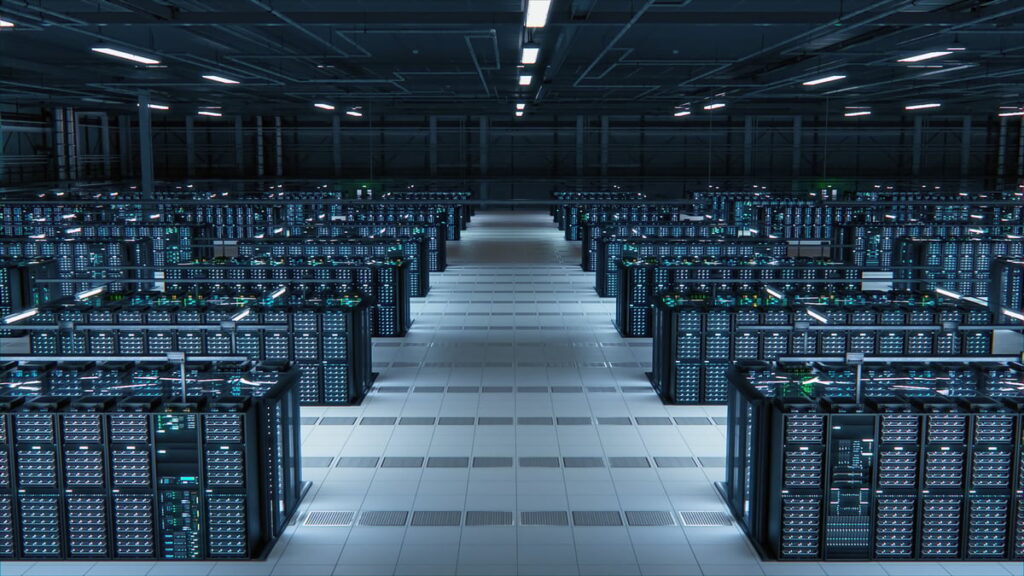 Rows of illuminated server racks line a central aisle in a large modern data center.