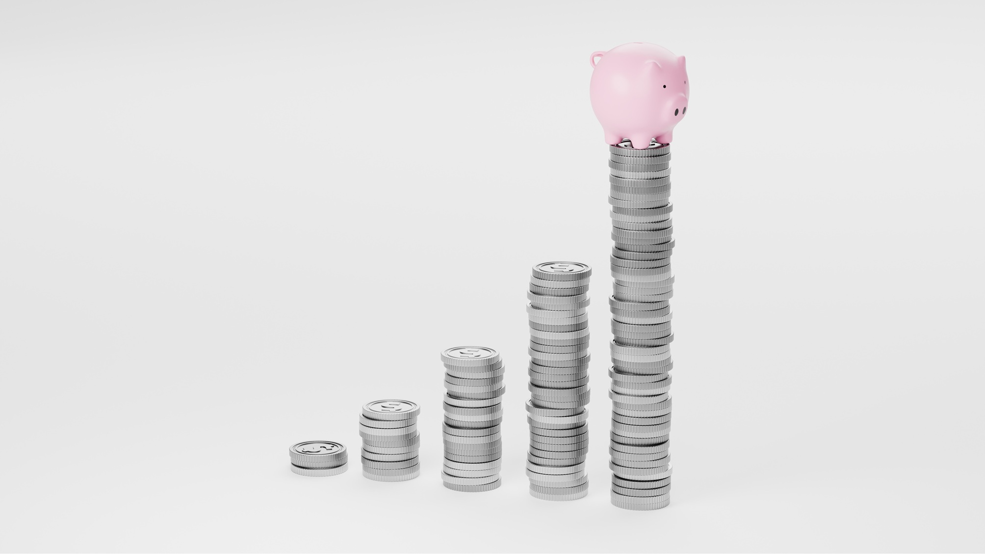 Several stacks of silver coins, a pink piggy bank on top of the tallest.