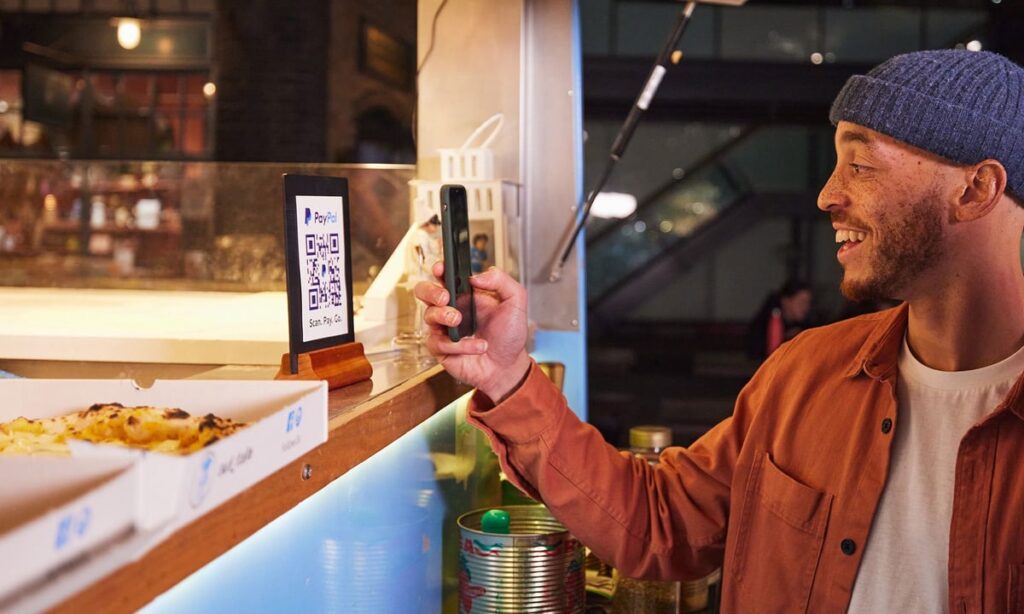 Person smiling while paying with PayPal.