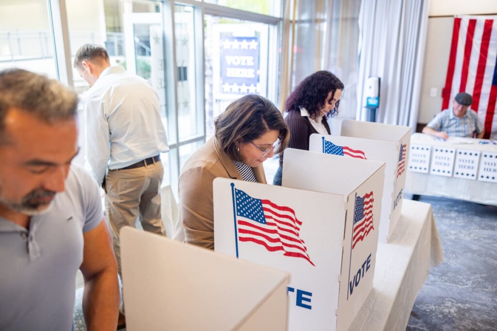 People voting at ballot boxes.
