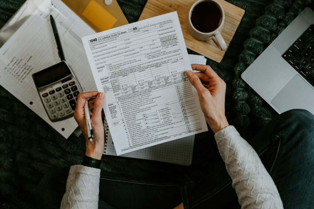 Side hustler reviewing 1099-K threshold tax forms and payment records