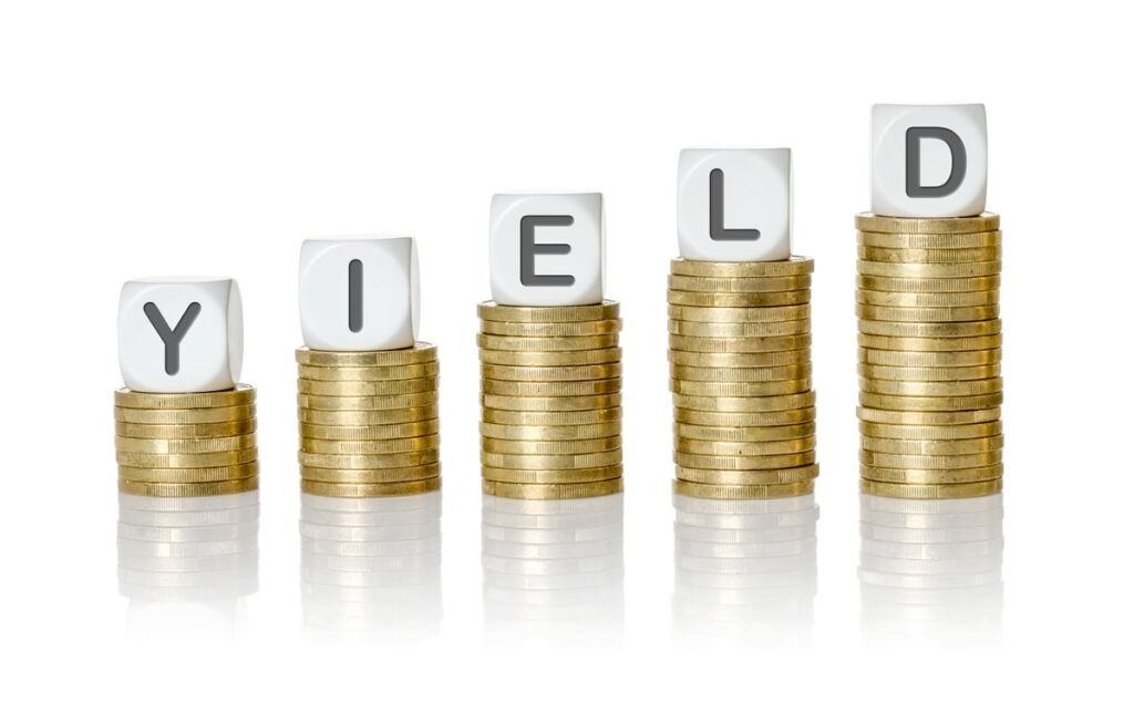 Dice spelling out yield on top of coin piles.